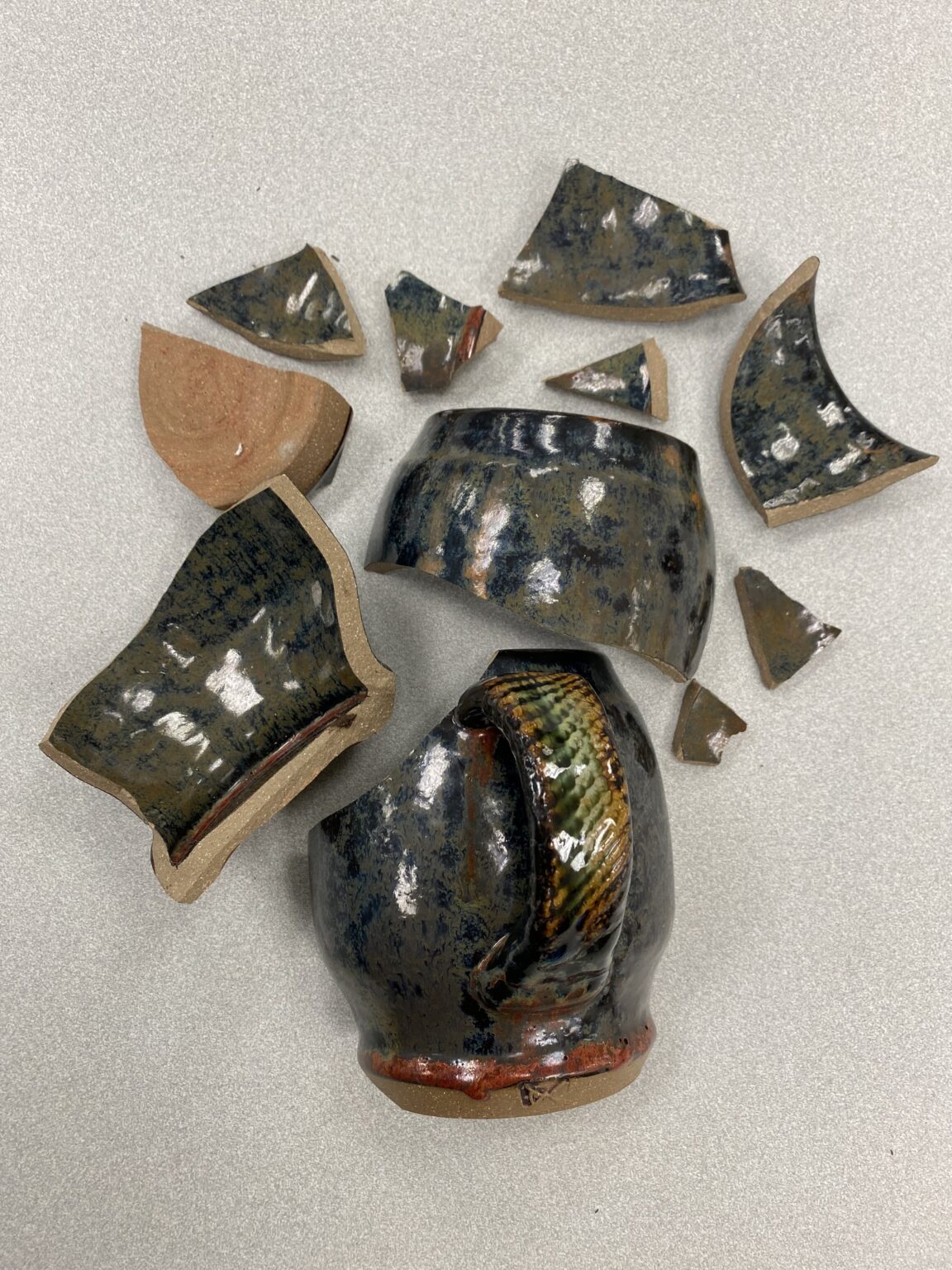 pieces of broken ceramic mug arranged neatly