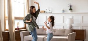 overjoyed young mommy babysitter dancing to music with girl picture id1257041198